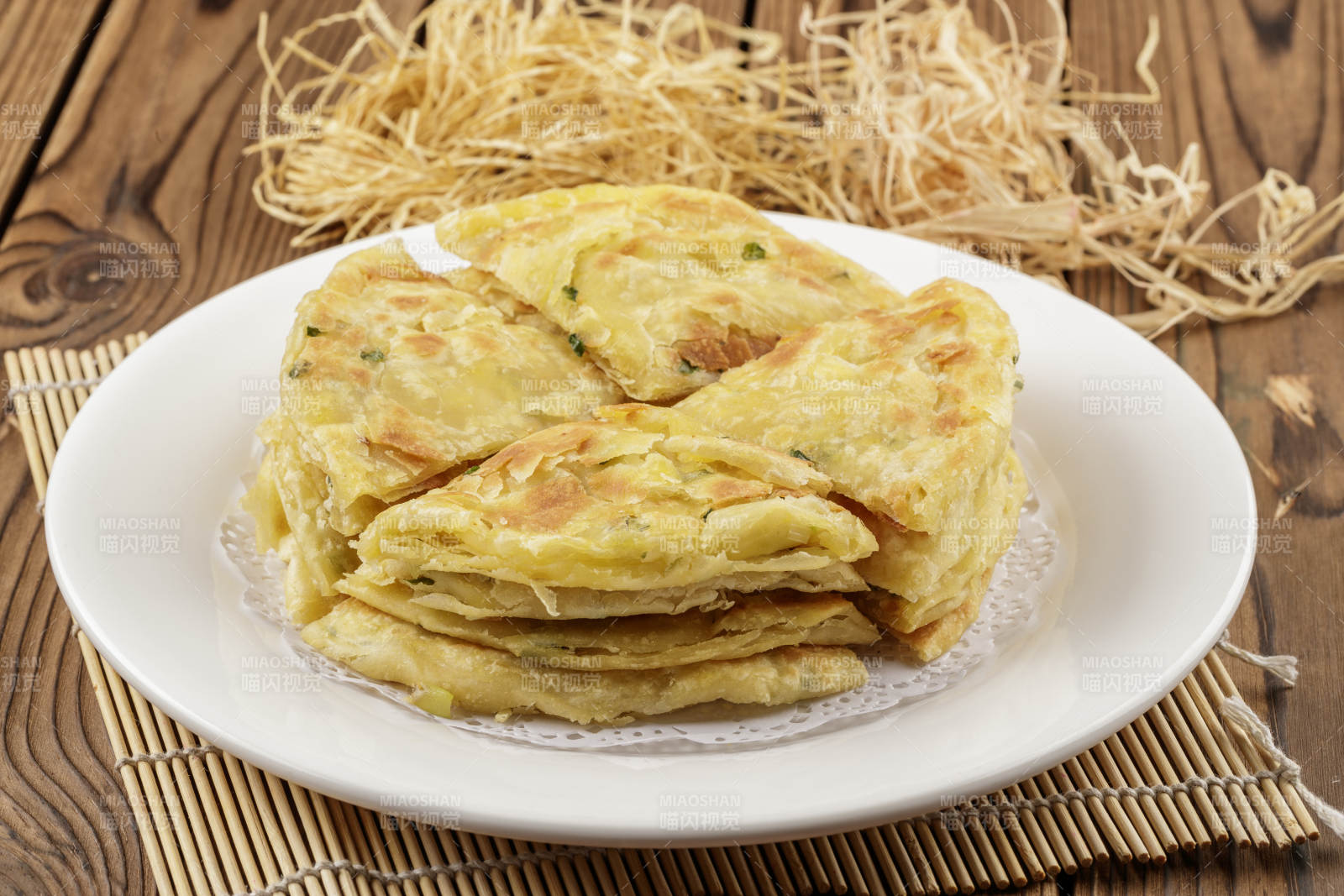 圆形白色瓷盘装的葱花饼图片