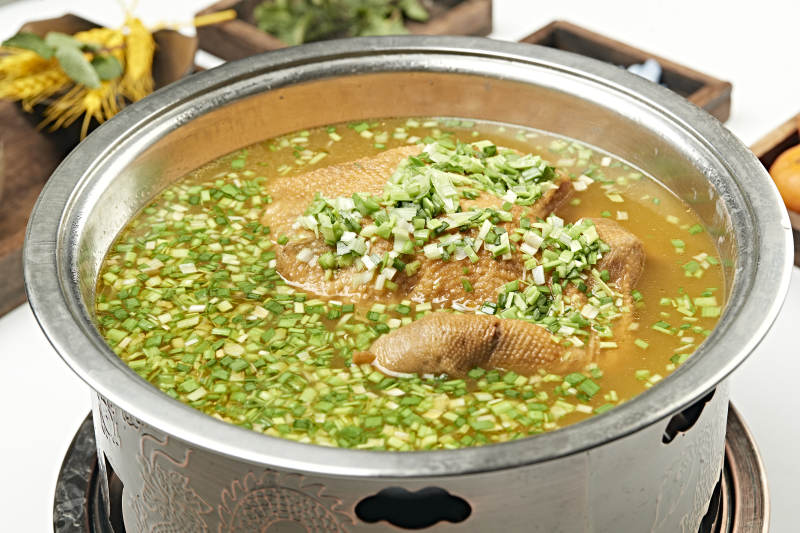 铜锅餐具装的葱香炖煮柴鸡汤图片