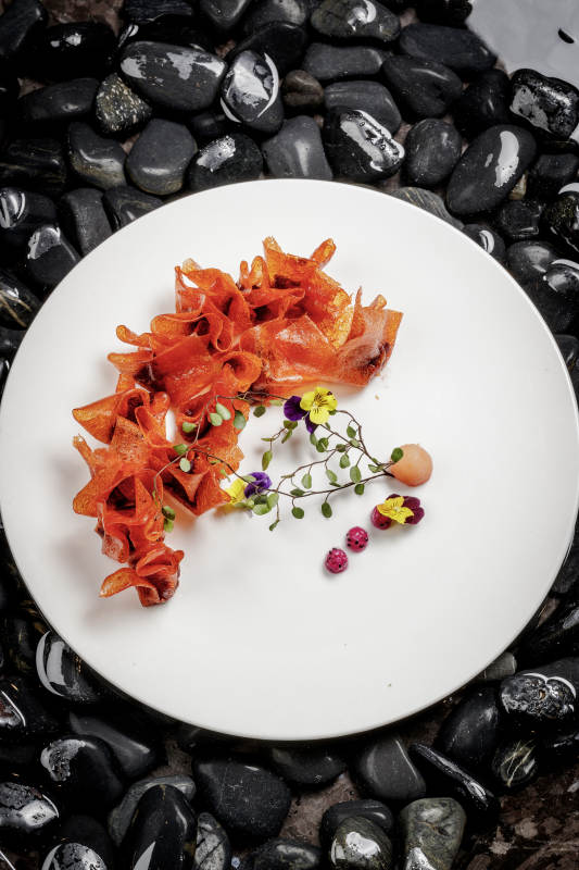 山楂陷炸馄饨摆放在布满鹅卵石的水中图片