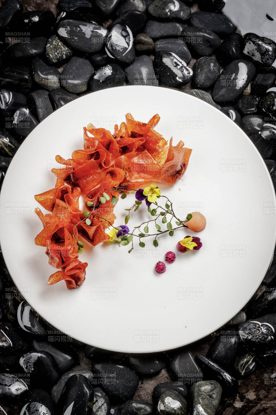 山楂陷炸馄饨摆放在布满鹅卵石的水中图片