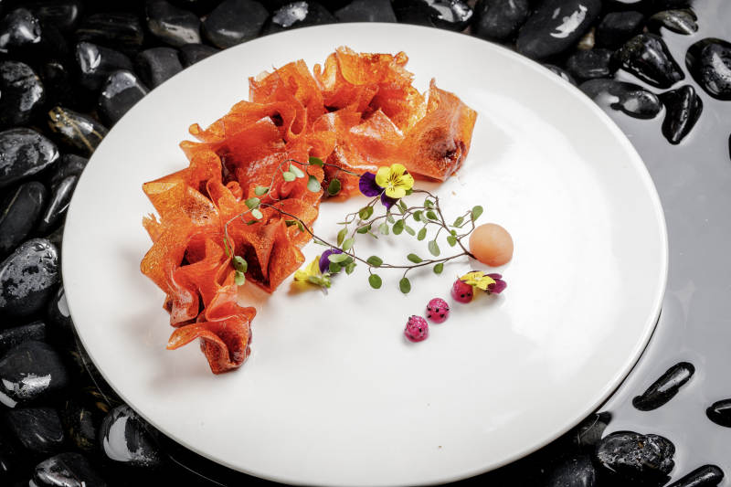 山楂陷炸馄饨摆放在布满鹅卵石的水中图片