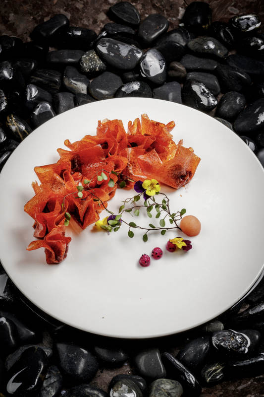 山楂陷炸馄饨摆放在布满鹅卵石的水中图片