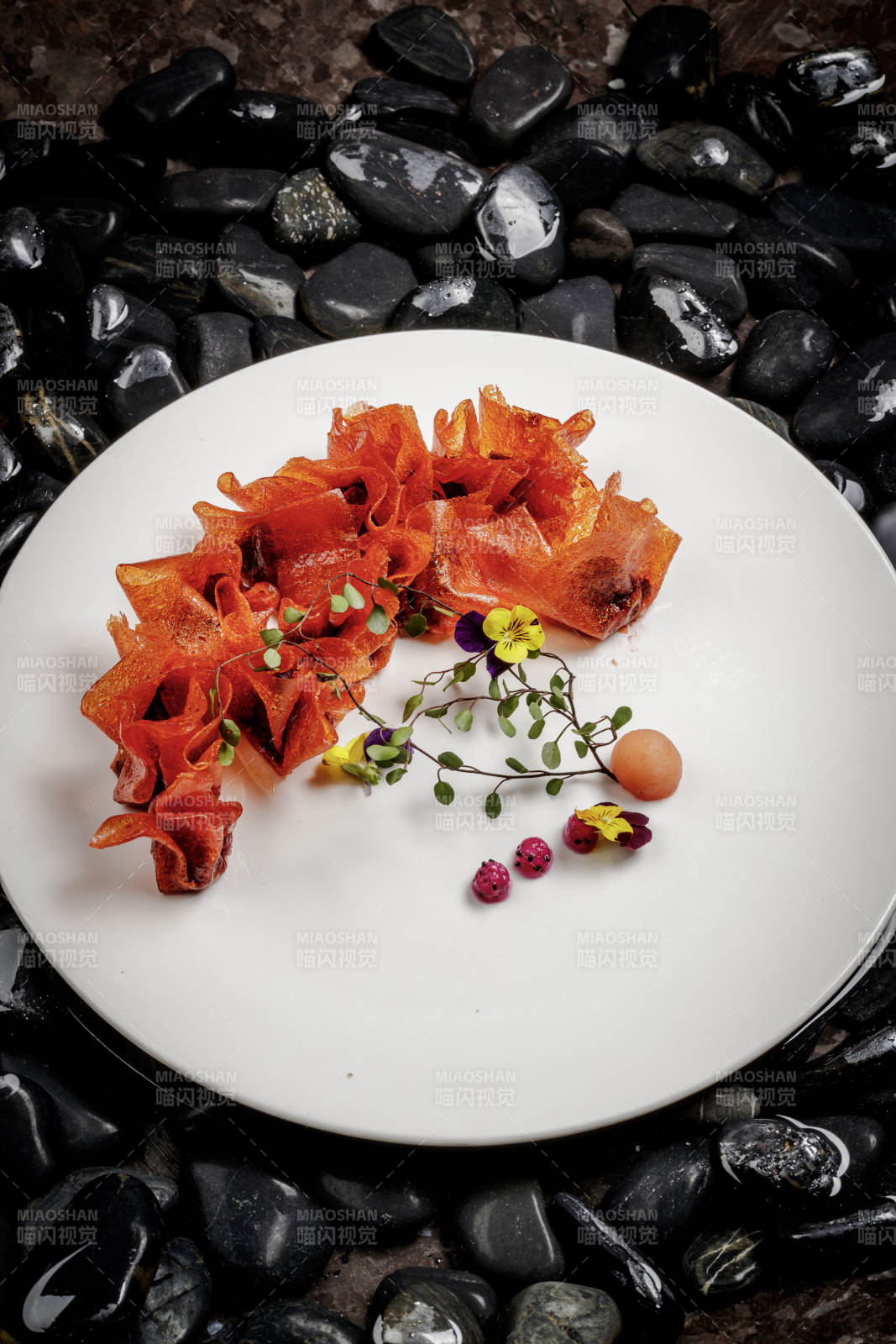 山楂陷炸馄饨摆放在布满鹅卵石的水中图片