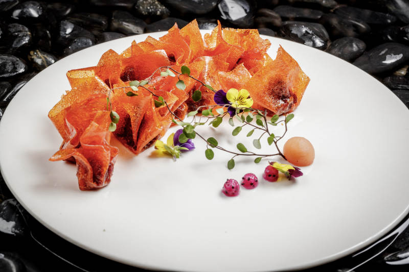 山楂陷炸馄饨摆放在布满鹅卵石的水中图片