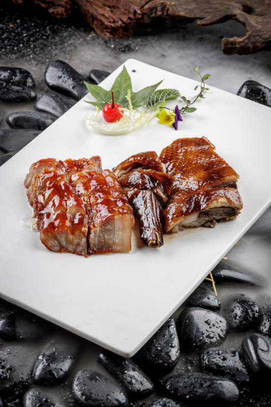 烧腊双拼摆放在干冰缭绕的鹅卵石上图片