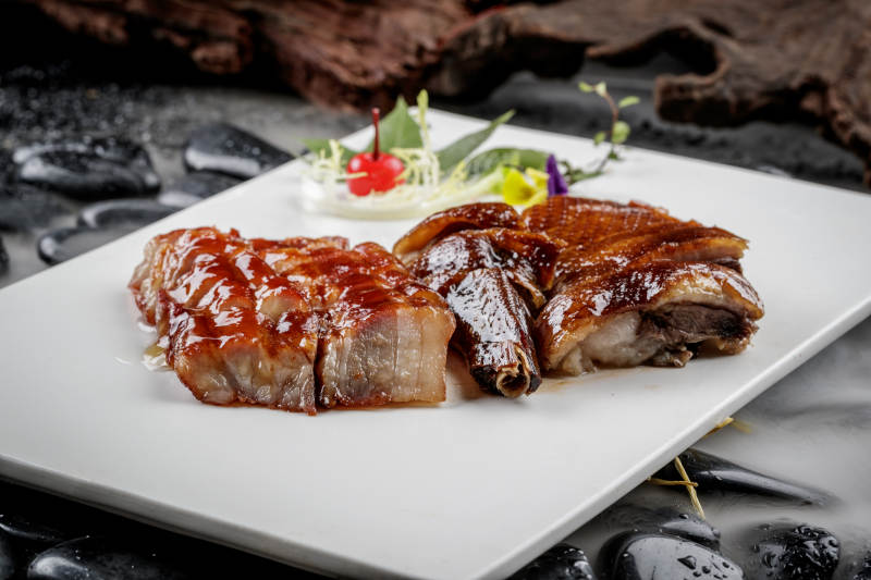 烧腊双拼摆放在干冰缭绕的鹅卵石上图片