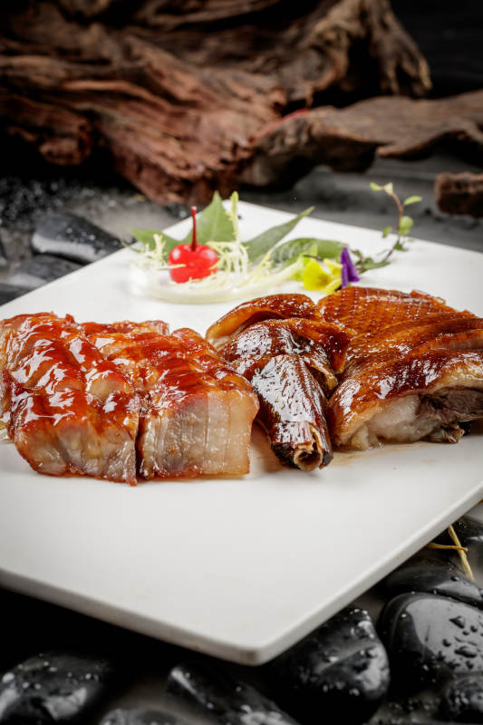 烧腊双拼摆放在干冰缭绕的鹅卵石上图片