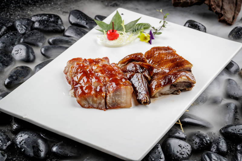 烧腊双拼摆放在干冰缭绕的鹅卵石上图片