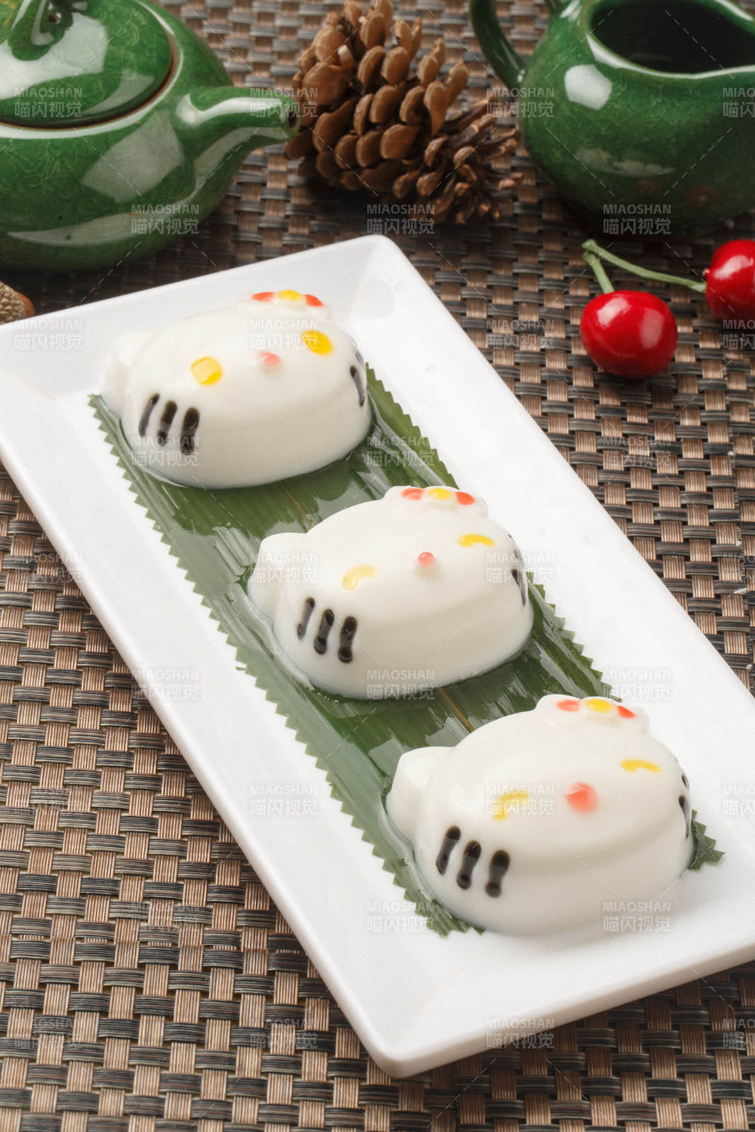 KT猫造型的糯米糕摆放在餐垫上图片