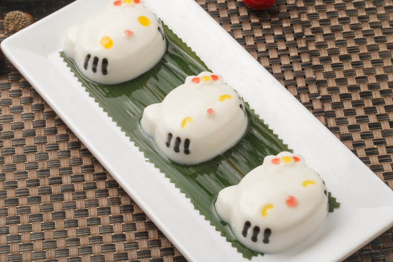 KT猫造型的糯米糕摆放在餐垫上图片