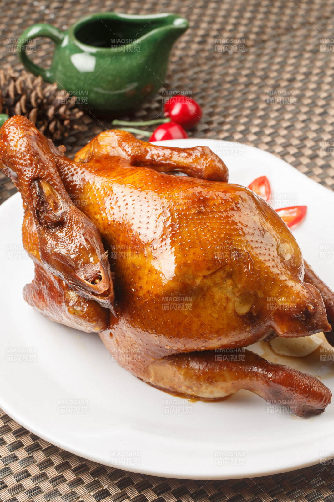 白色圆瓷盘装的港式脆皮鸡摆放在餐垫上图片