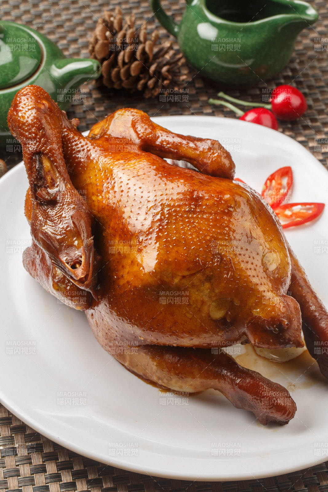 白色圆瓷盘装的港式脆皮鸡摆放在餐垫上图片