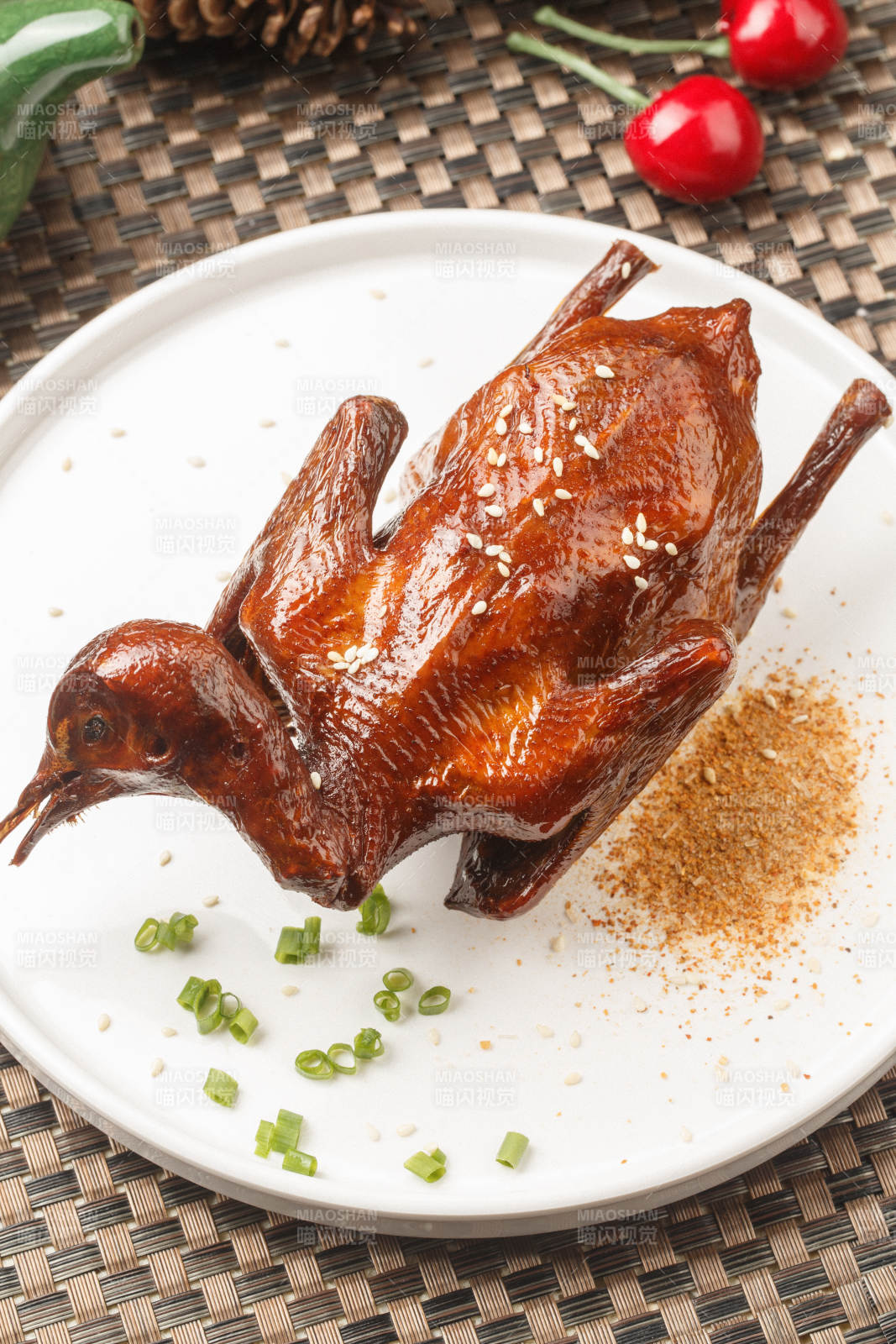 圆形白瓷盘装的港式脆皮乳鸽摆放在餐垫上图片