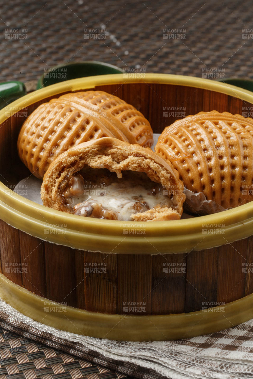 笼屉装的港式奶油菠萝包摆放在餐布上图片