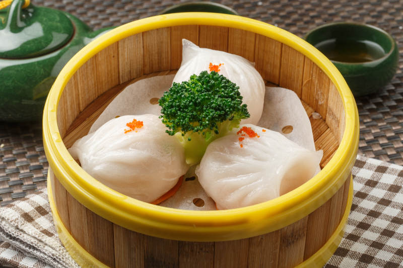 笼屉装的港式奶油菠萝包摆放在餐布上图片