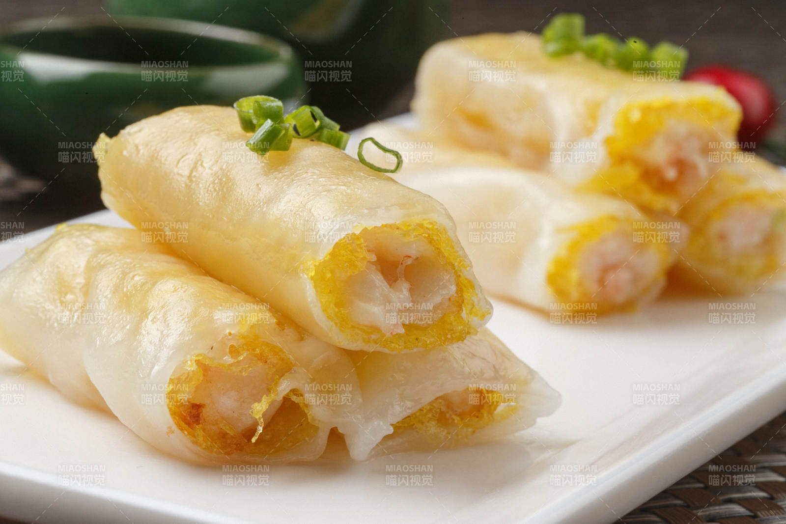 长方形白瓷盘装的虾仁肠粉摆放在餐垫上图片