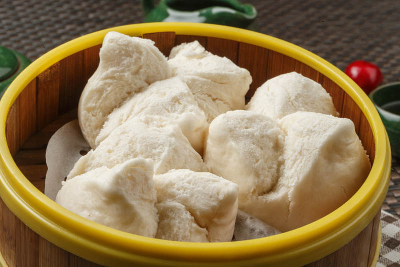 长方形白瓷盘装的虾仁肠粉摆放在餐垫上图片