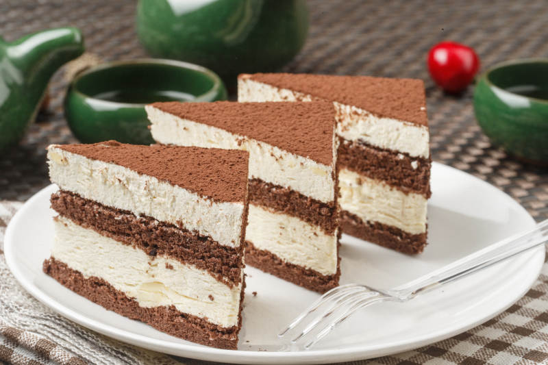 巧克力撒粉奶油慕斯摆放在餐布上图片