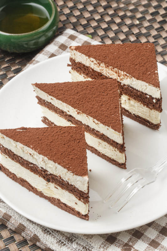 巧克力撒粉奶油慕斯摆放在餐布上图片