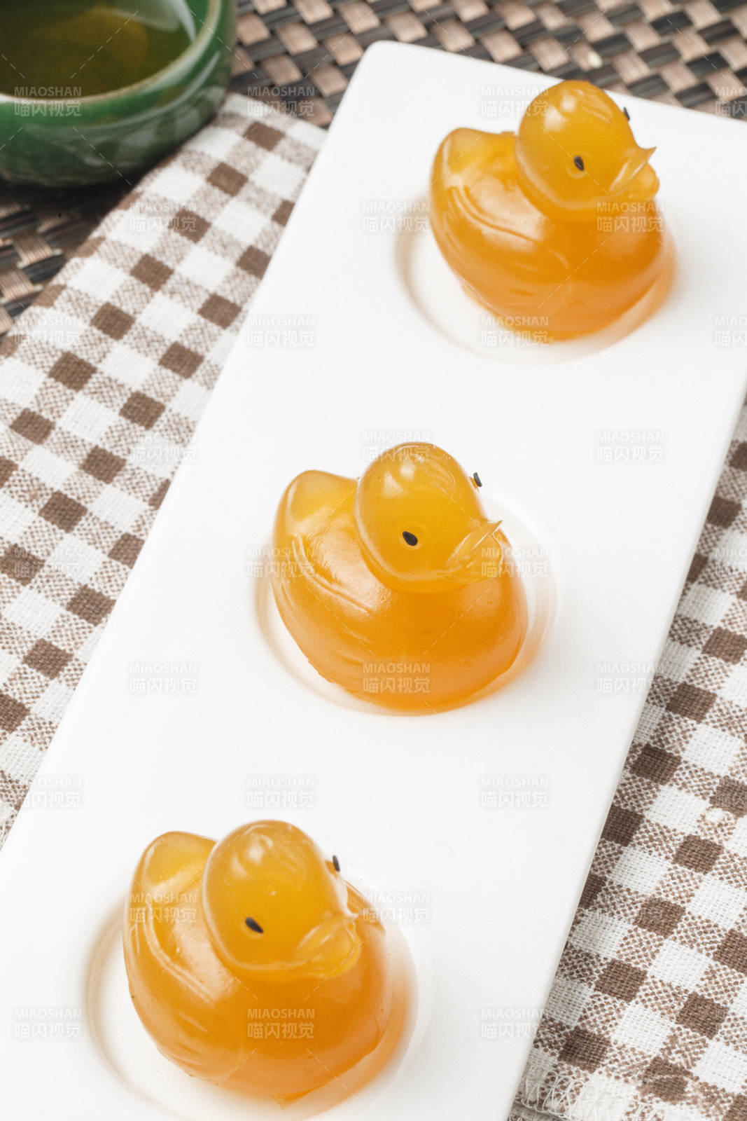 小黄鸭造型芒果糕摆放在餐布上图片