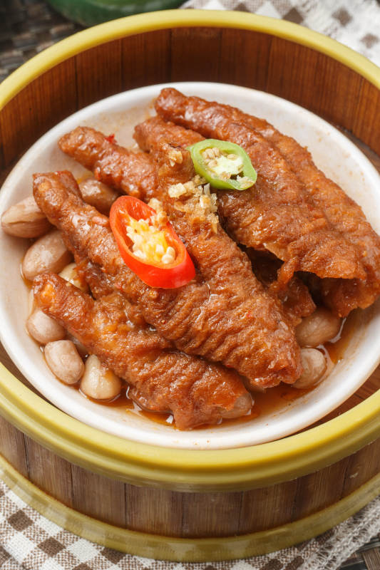 笼屉装的蒸凤爪摆放在餐布上图片