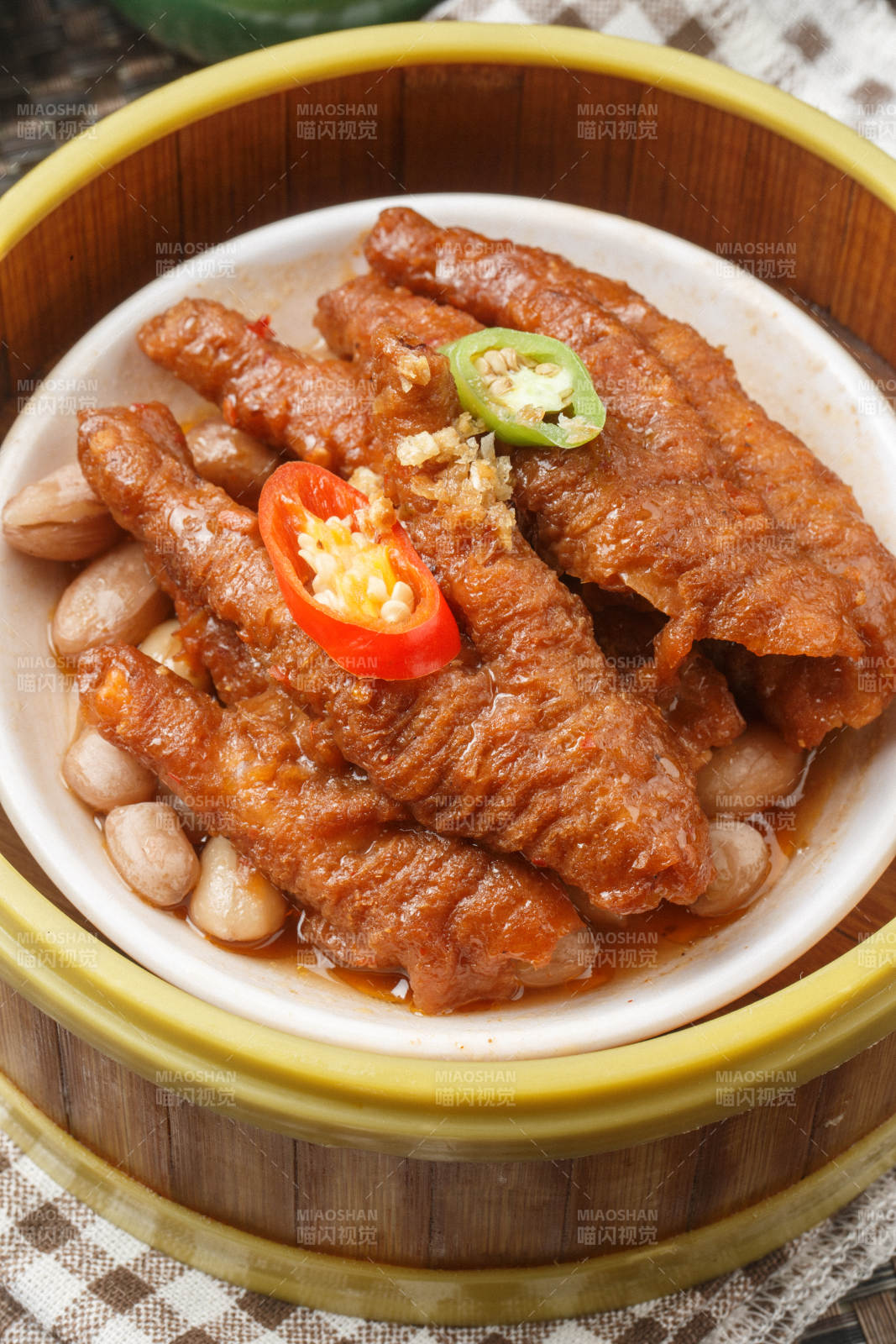 笼屉装的蒸凤爪摆放在餐布上图片