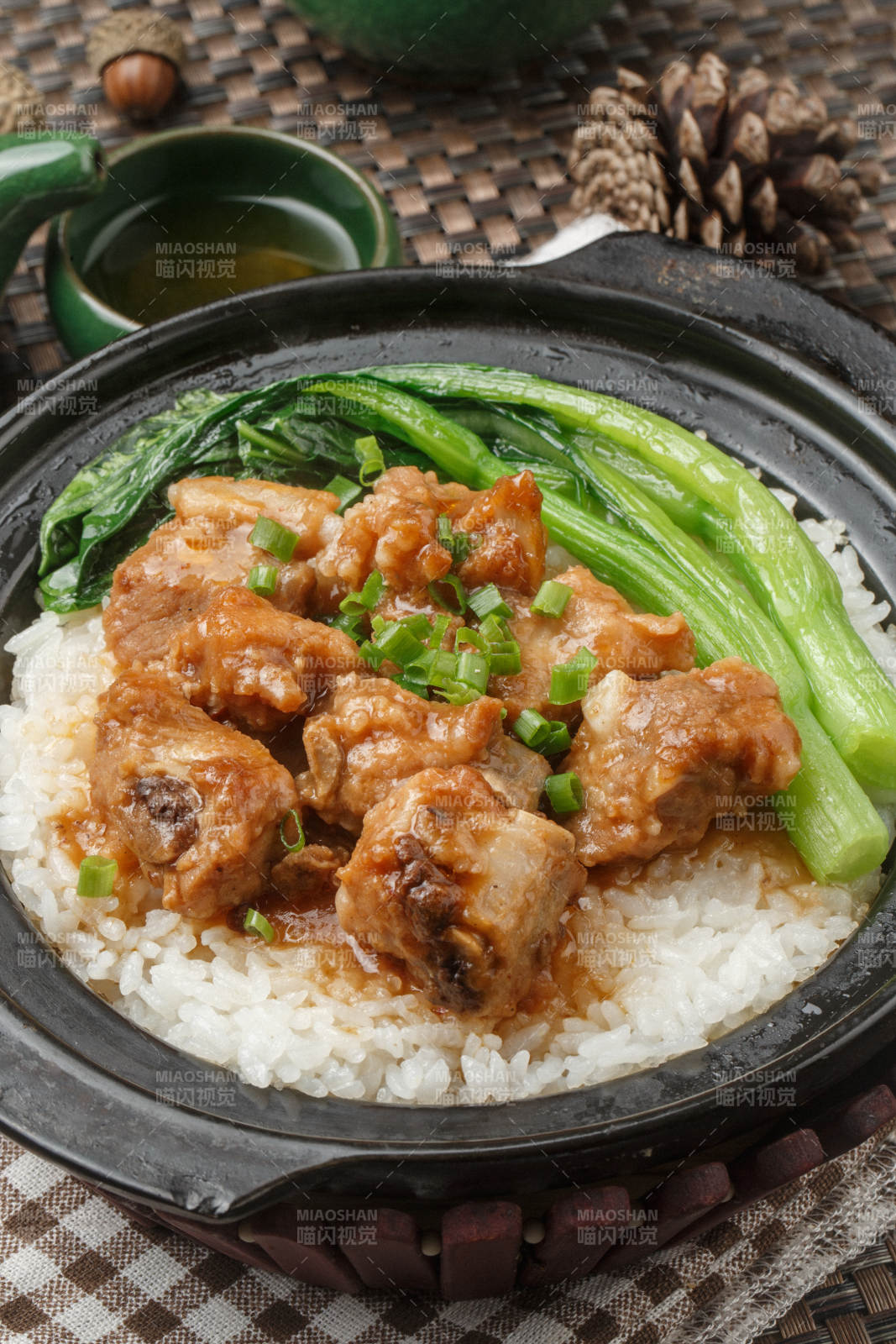 黑色砂锅装的虫草花排骨煲白粥摆放在餐布上图片