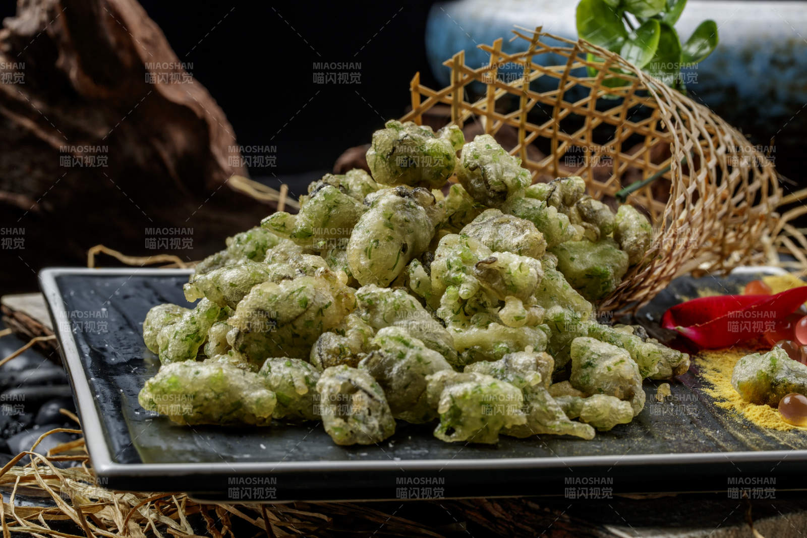 黑色石盘装的香酥香椿炸牡蛎图片