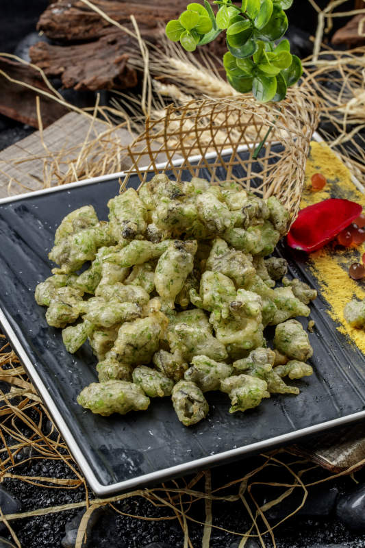 黑色石盘装的香酥香椿炸牡蛎图片