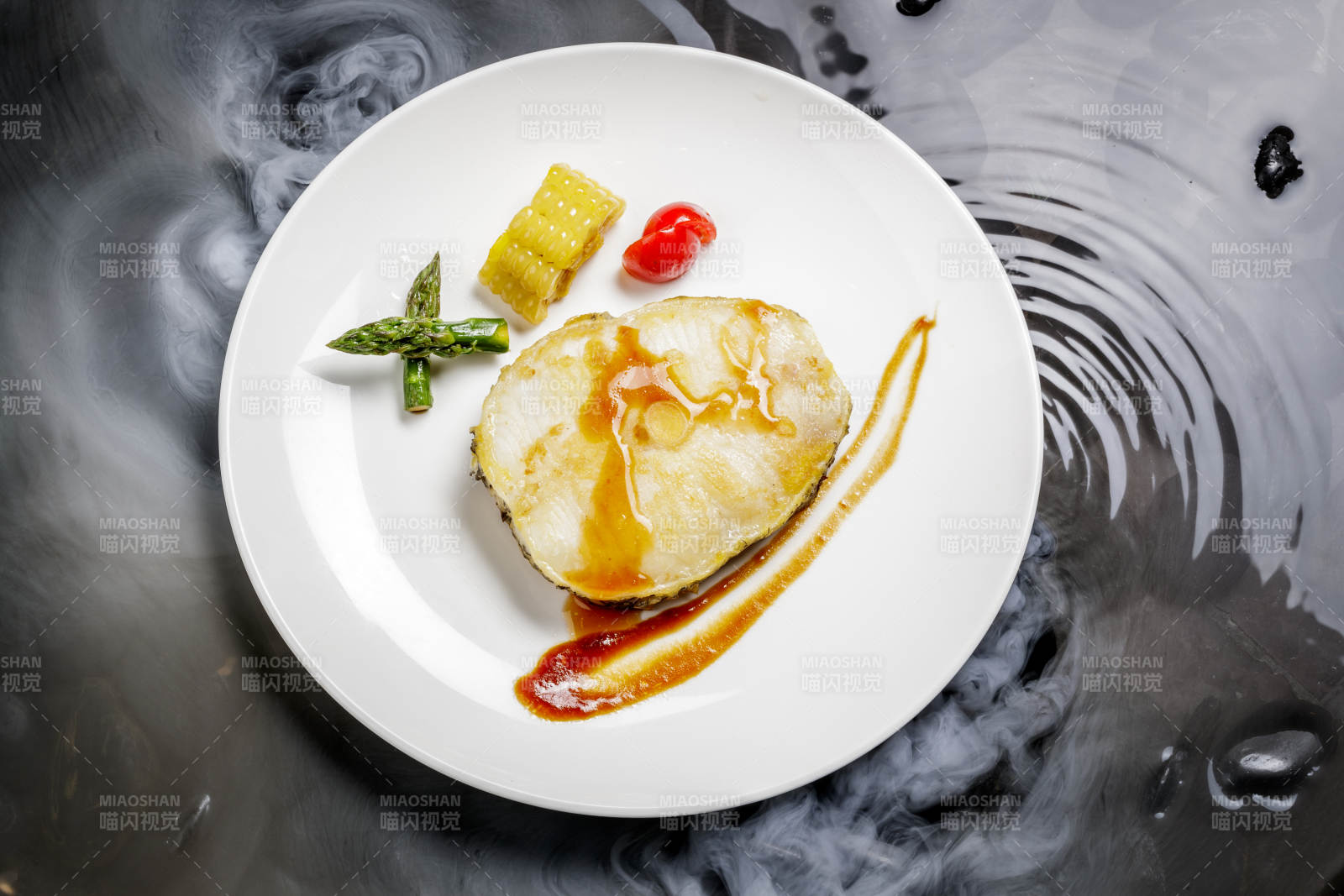 香煎银鳕鱼摆放在干冰缭绕的水中图片