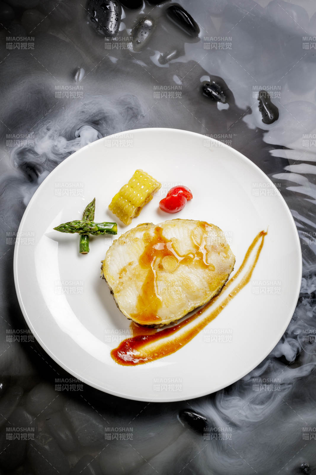 香煎银鳕鱼摆放在干冰缭绕的水中图片