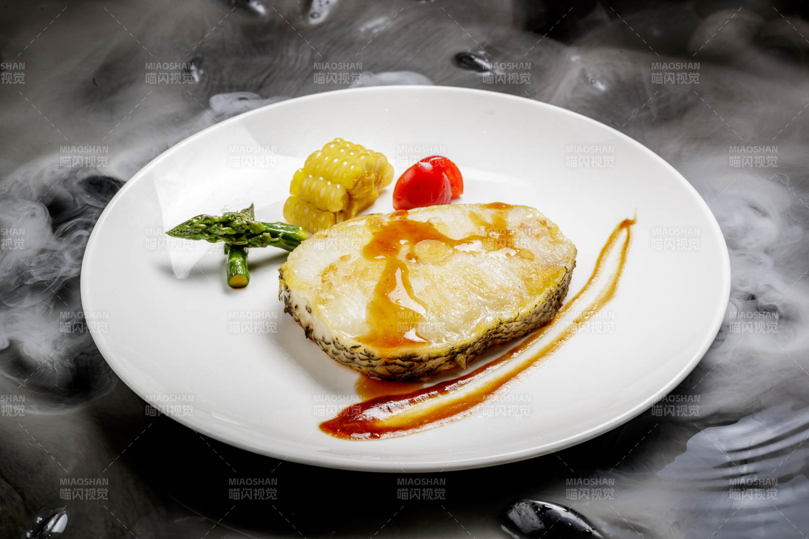 香煎银鳕鱼摆放在干冰缭绕的水中图片