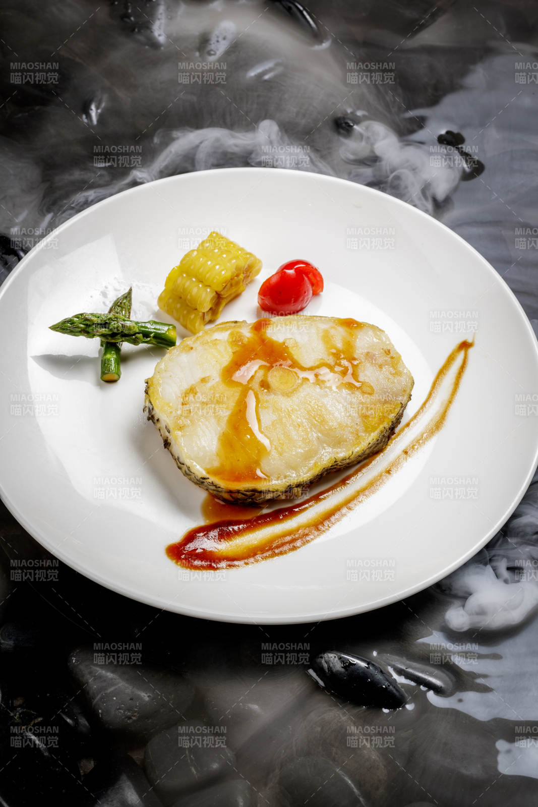 香煎银鳕鱼摆放在干冰缭绕的水中图片