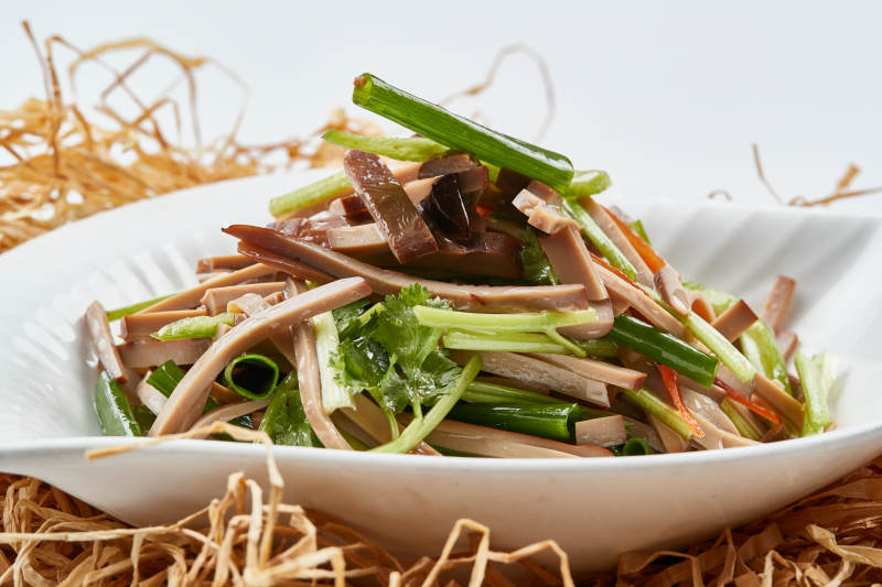 白色瓷盘装的苦菊拌香干图片