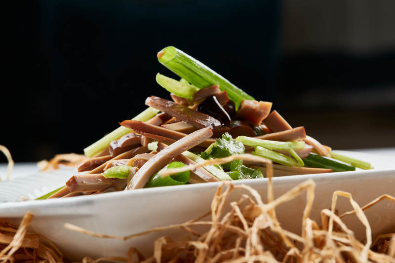 白色瓷盘装的苦菊拌香干图片