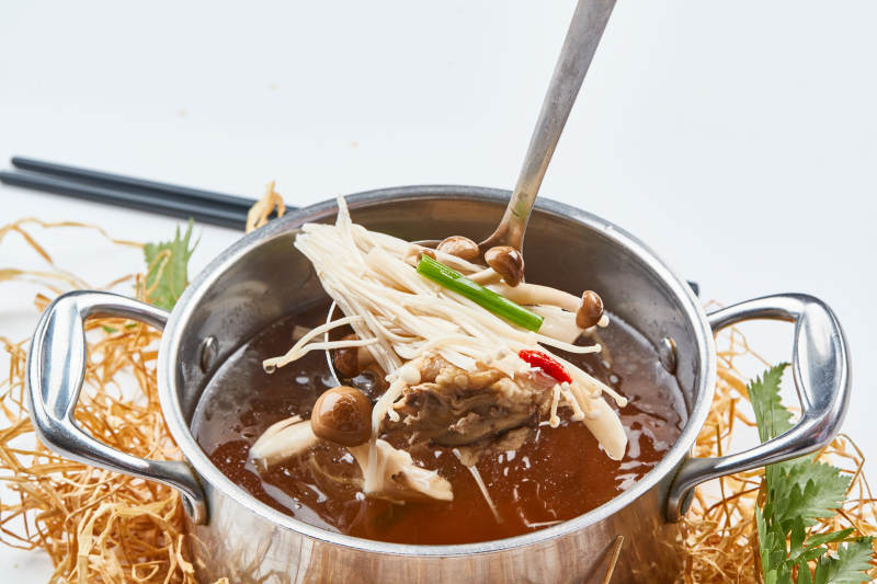 不锈钢汤锅装的火锅汤底山珍菌汤图片