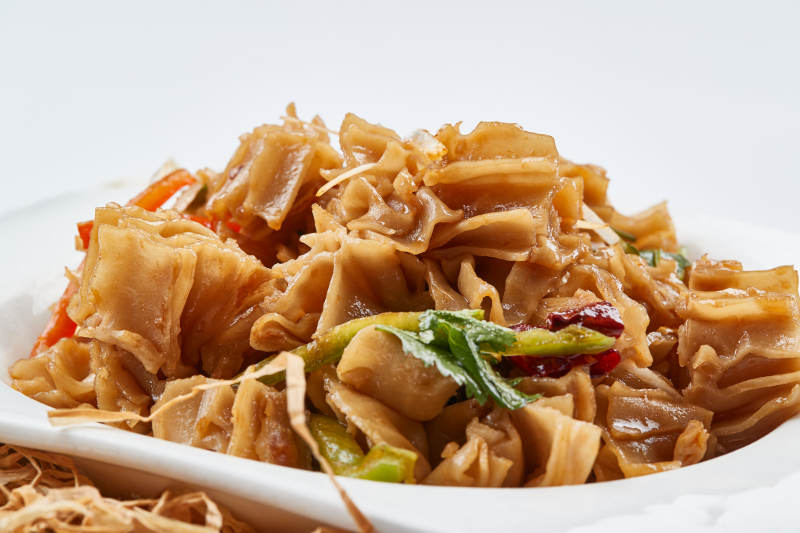 白色瓷盘装的凉拌莜面窝窝图片