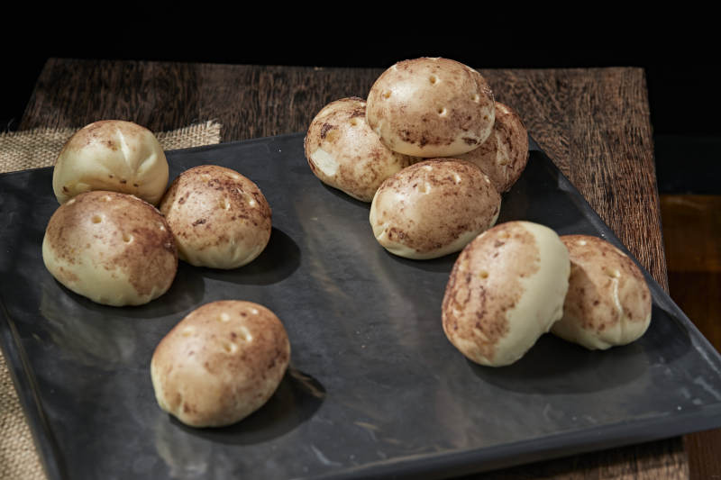 杂粮土豆包摆放在寿司帘上图片