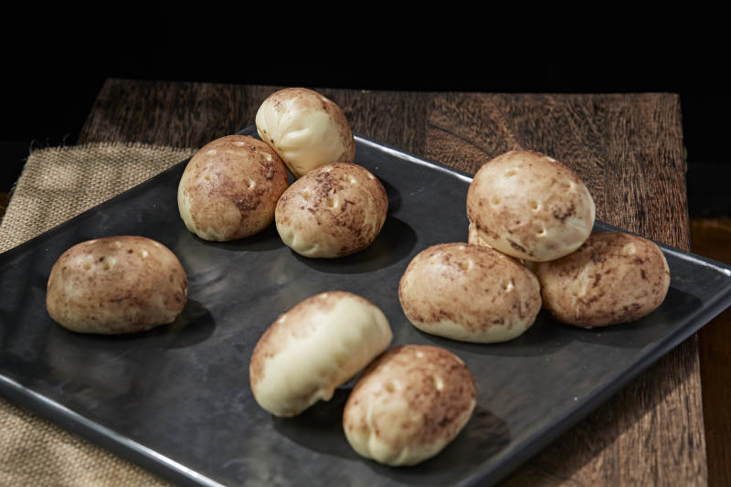 杂粮土豆包摆放在寿司帘上图片