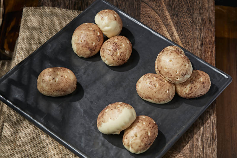 杂粮土豆包摆放在寿司帘上图片