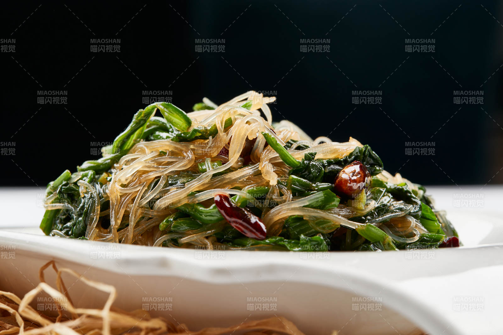 白色瓷盘装的凉拌粉丝菠菜图片