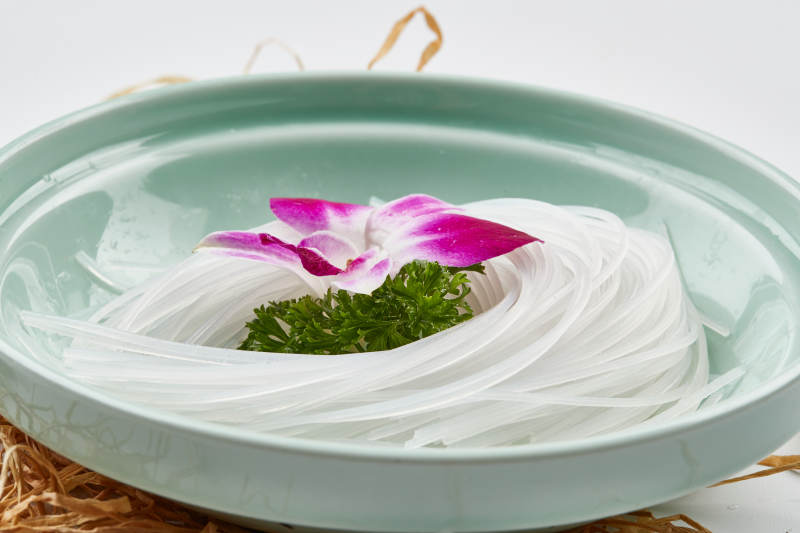 青色瓷盘装的火锅食材红薯粉条图片