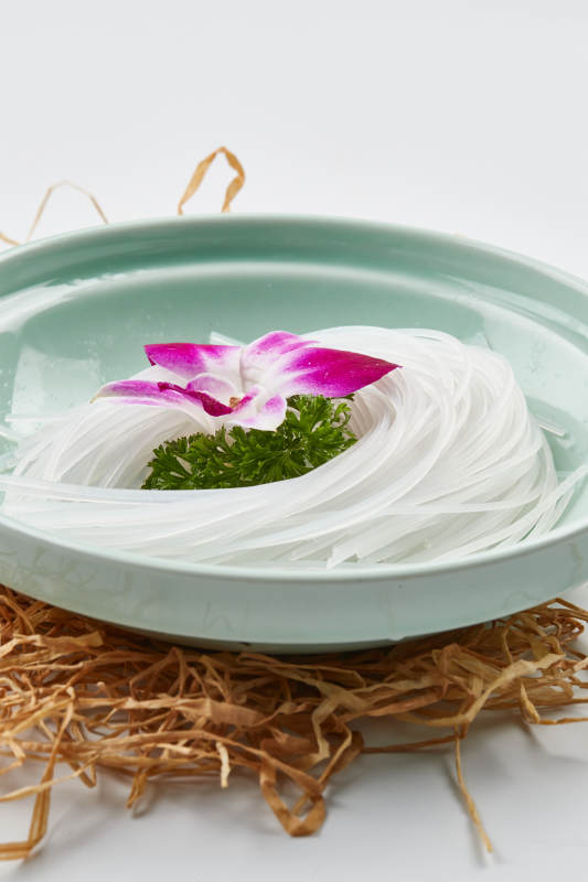 青色瓷盘装的火锅食材红薯粉条图片