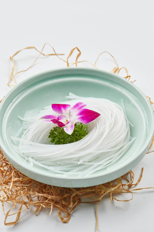 青色瓷盘装的火锅食材红薯粉条图片