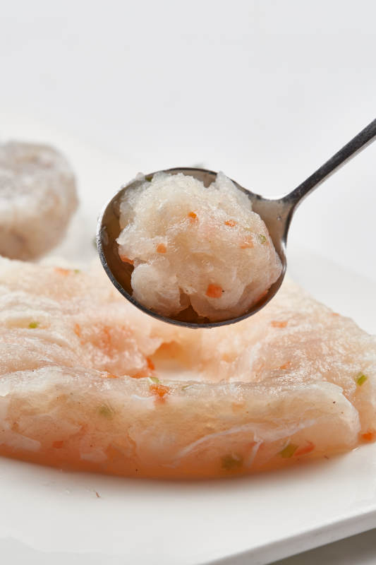 白色瓷盘装的火锅食材鱼滑虾滑图片