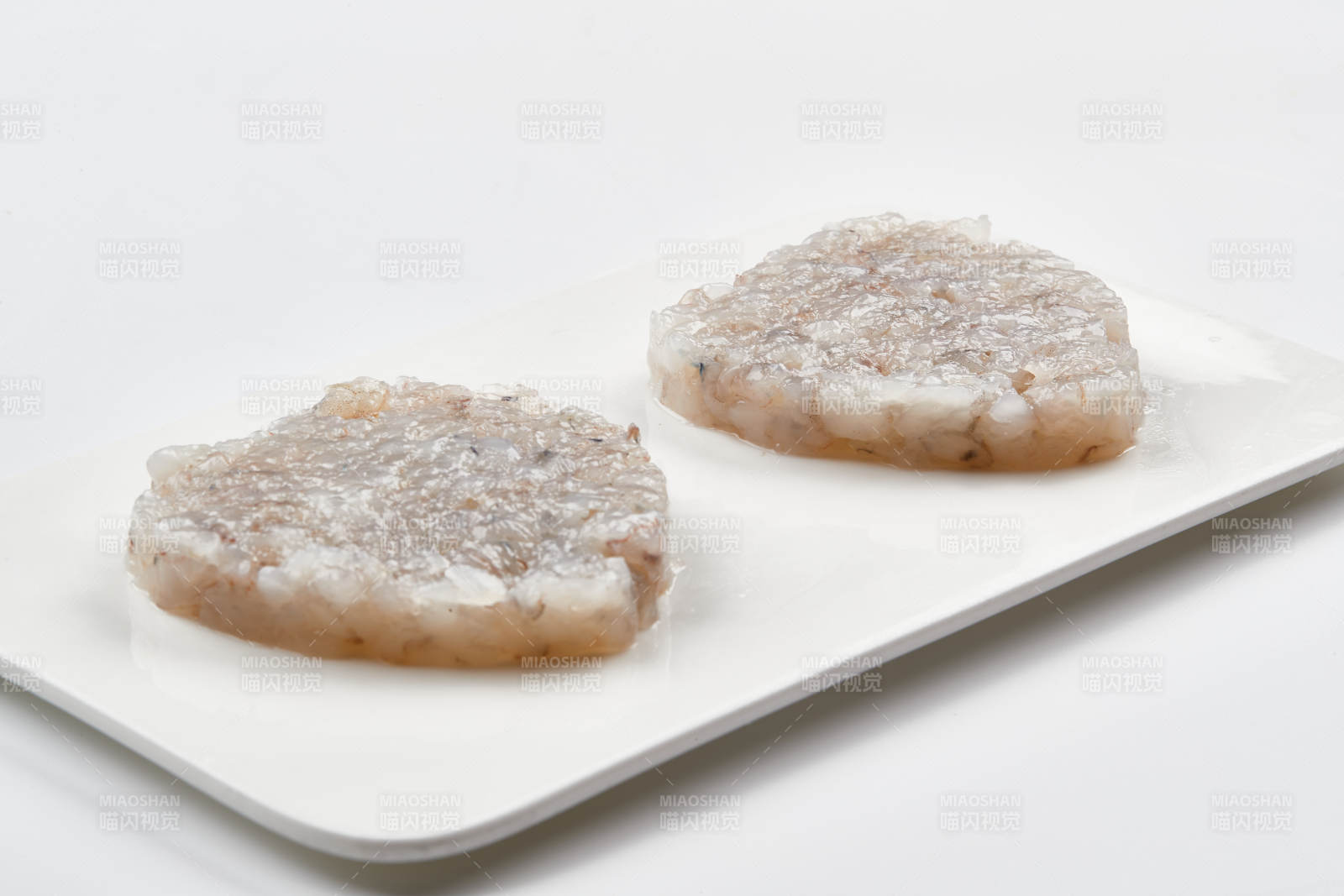 白色瓷盘装的火锅食材鱼滑虾滑图片