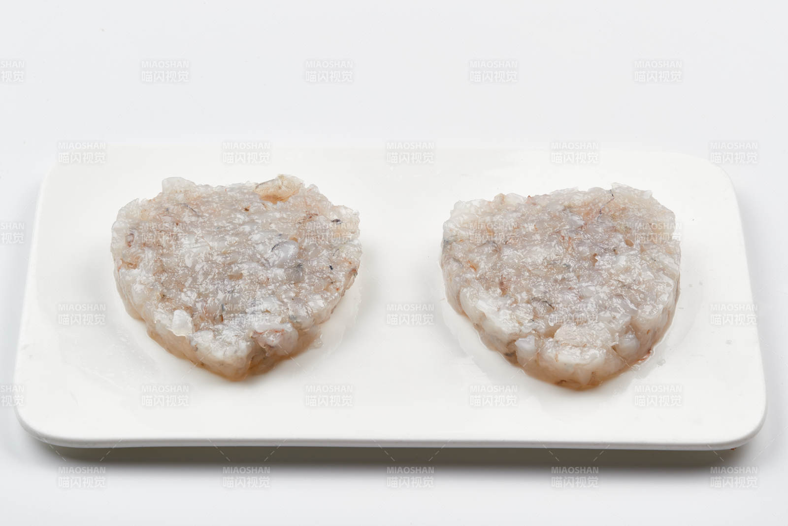 白色瓷盘装的火锅食材鱼滑虾滑图片