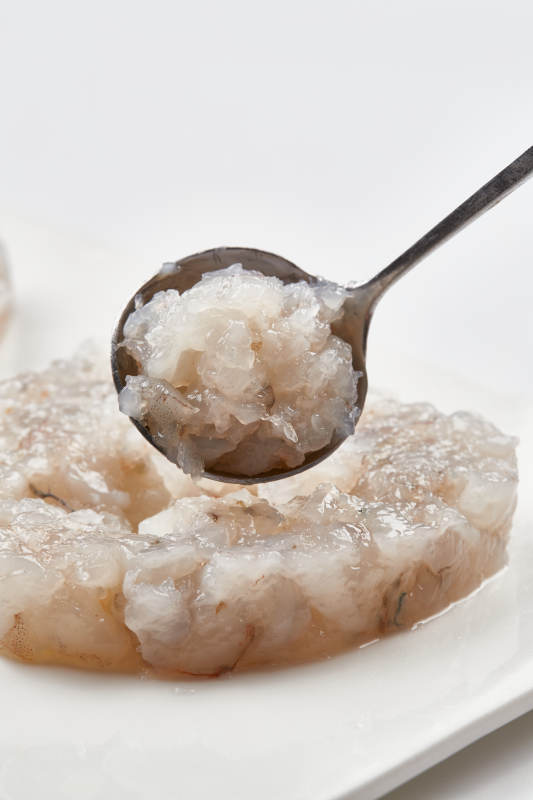 白色瓷盘装的火锅食材鱼滑虾滑图片