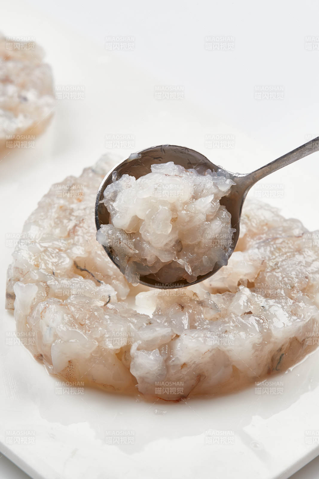 白色瓷盘装的火锅食材鱼滑虾滑图片