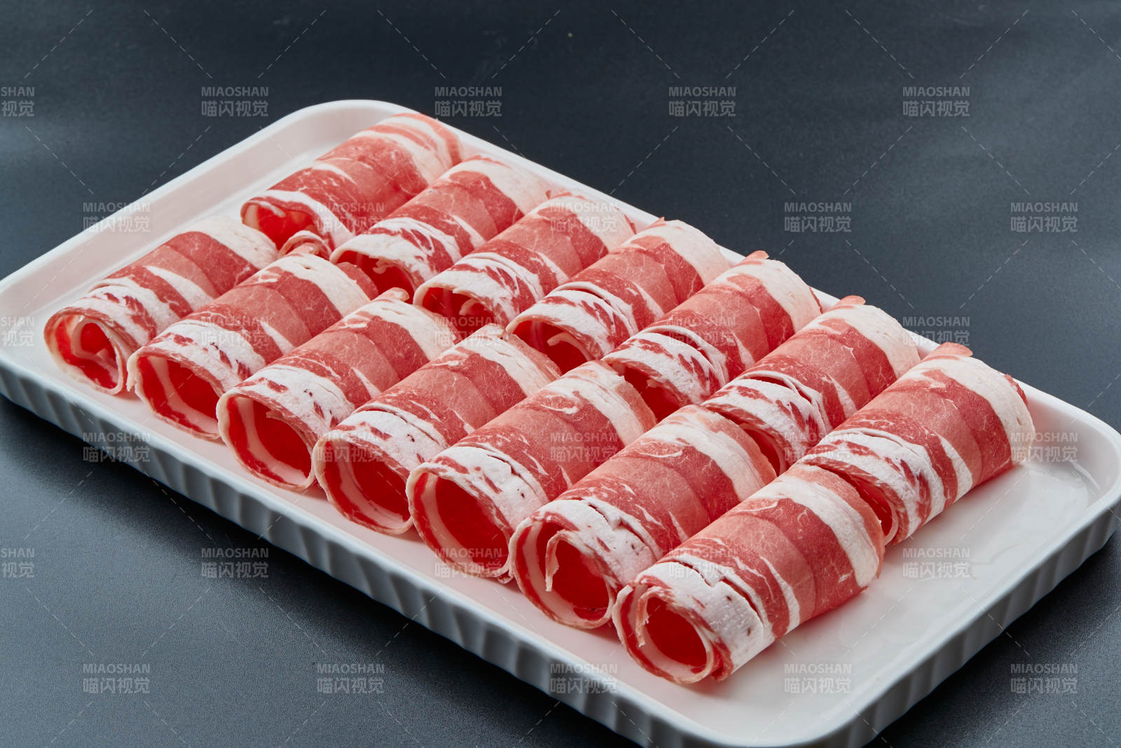 干冰缭绕的背景上摆放的草原肥羊肉卷图片